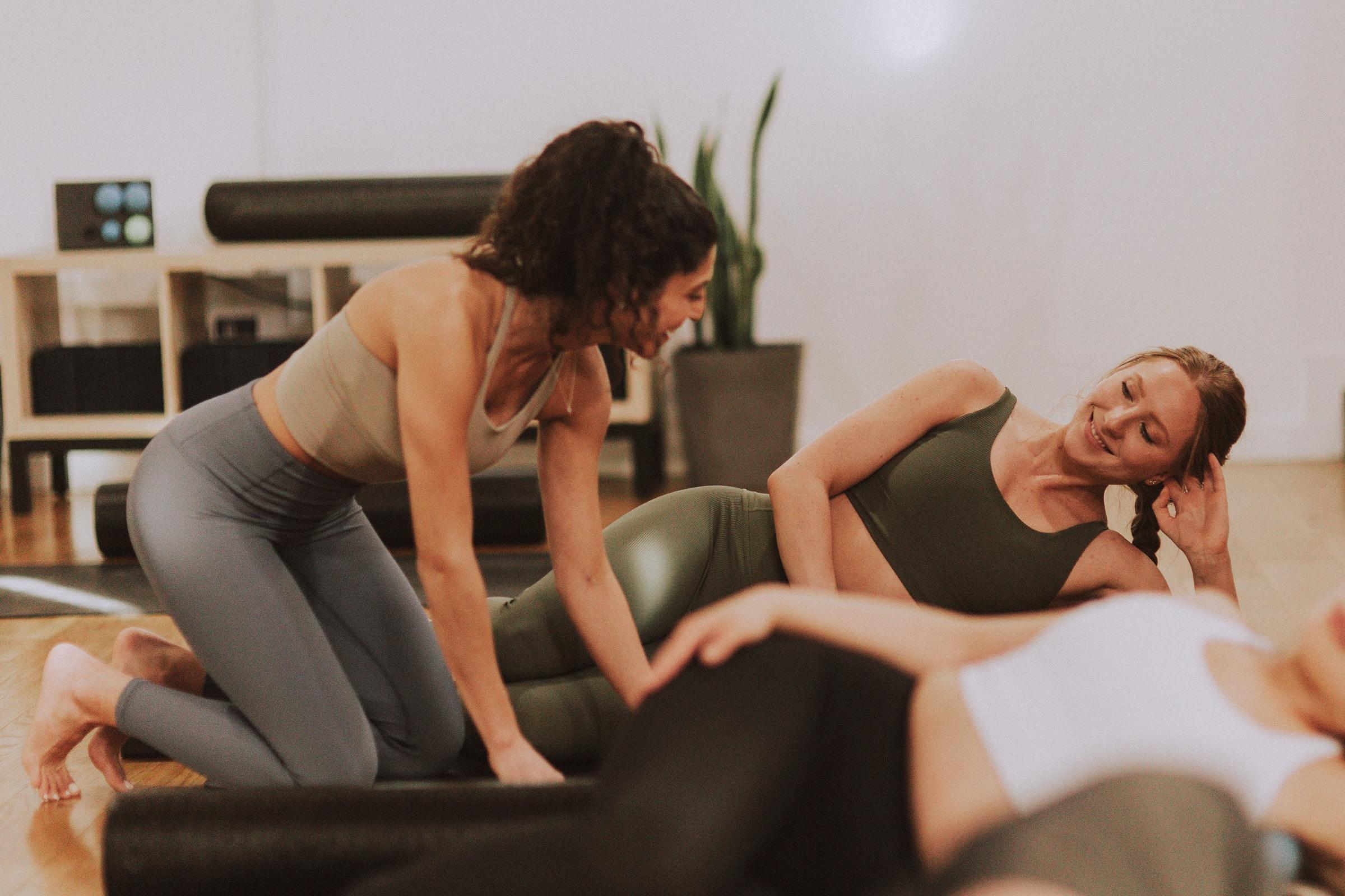 Jen and Gabby sharing a laugh together during a mat Pilates class